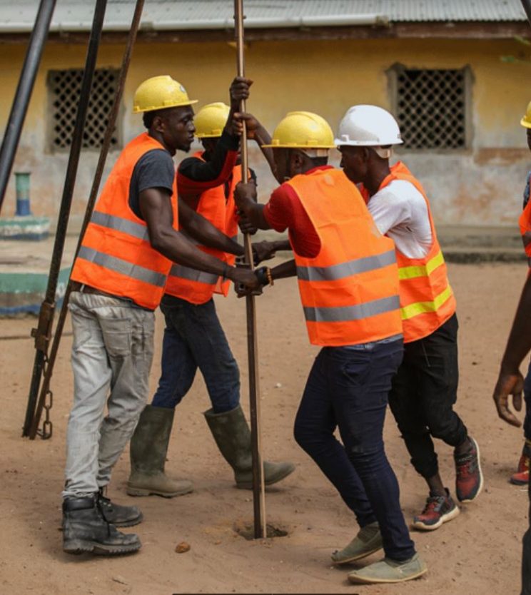 Several men work to set up a drill in their African village to provide fresh, clean water through Water4.